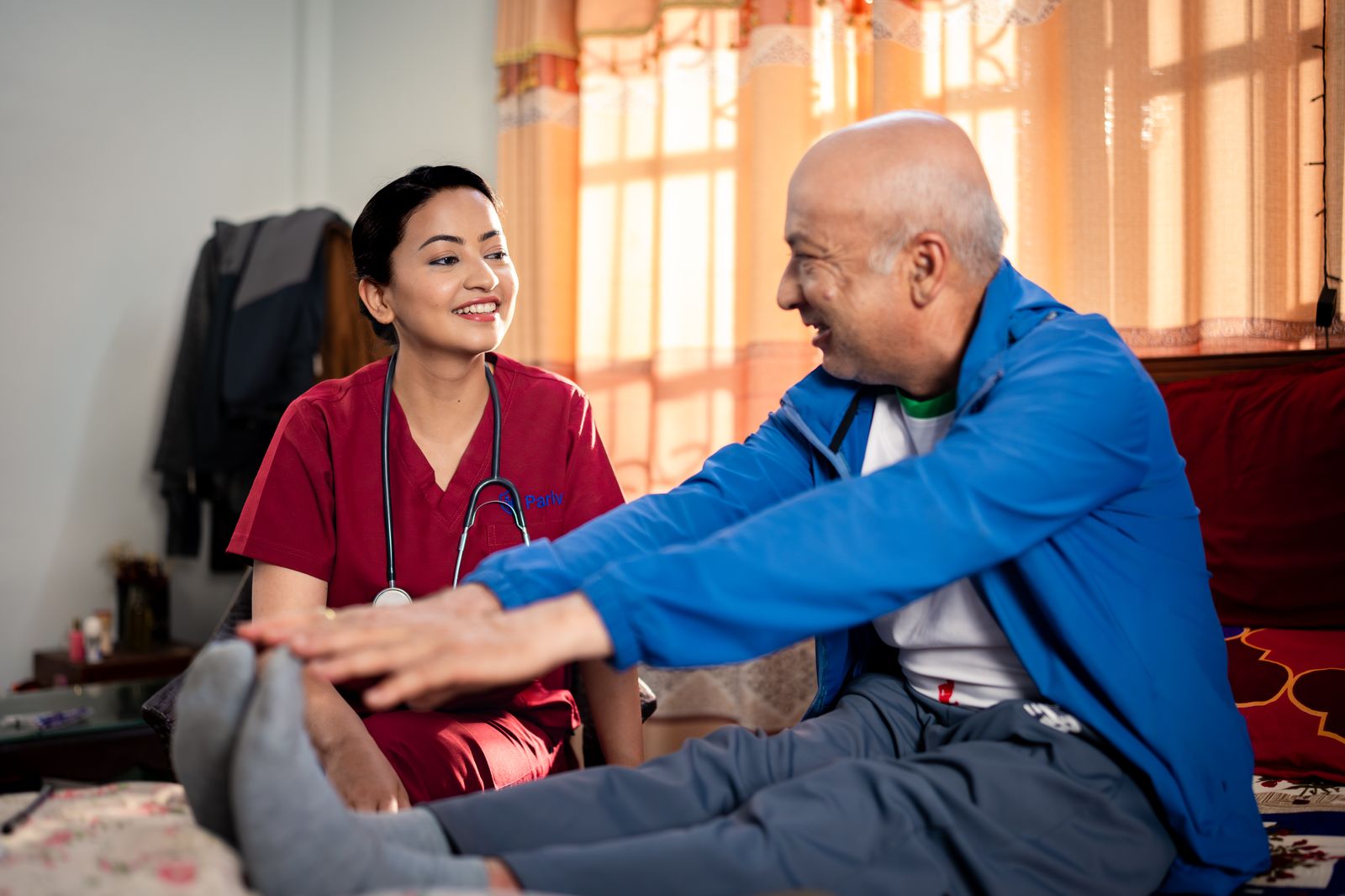 Parivar nurse sharing a warm moment with an elderly patient during a home visit in Nepal
