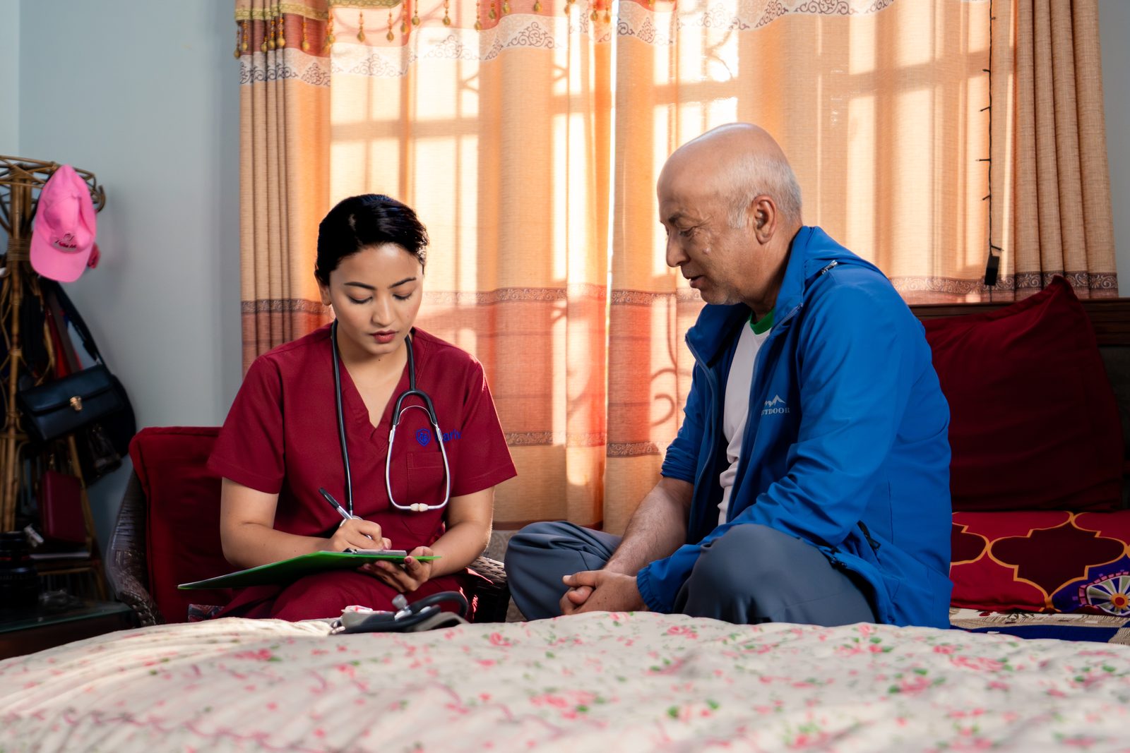 Nurse checking blood pressure of elderly patient at home