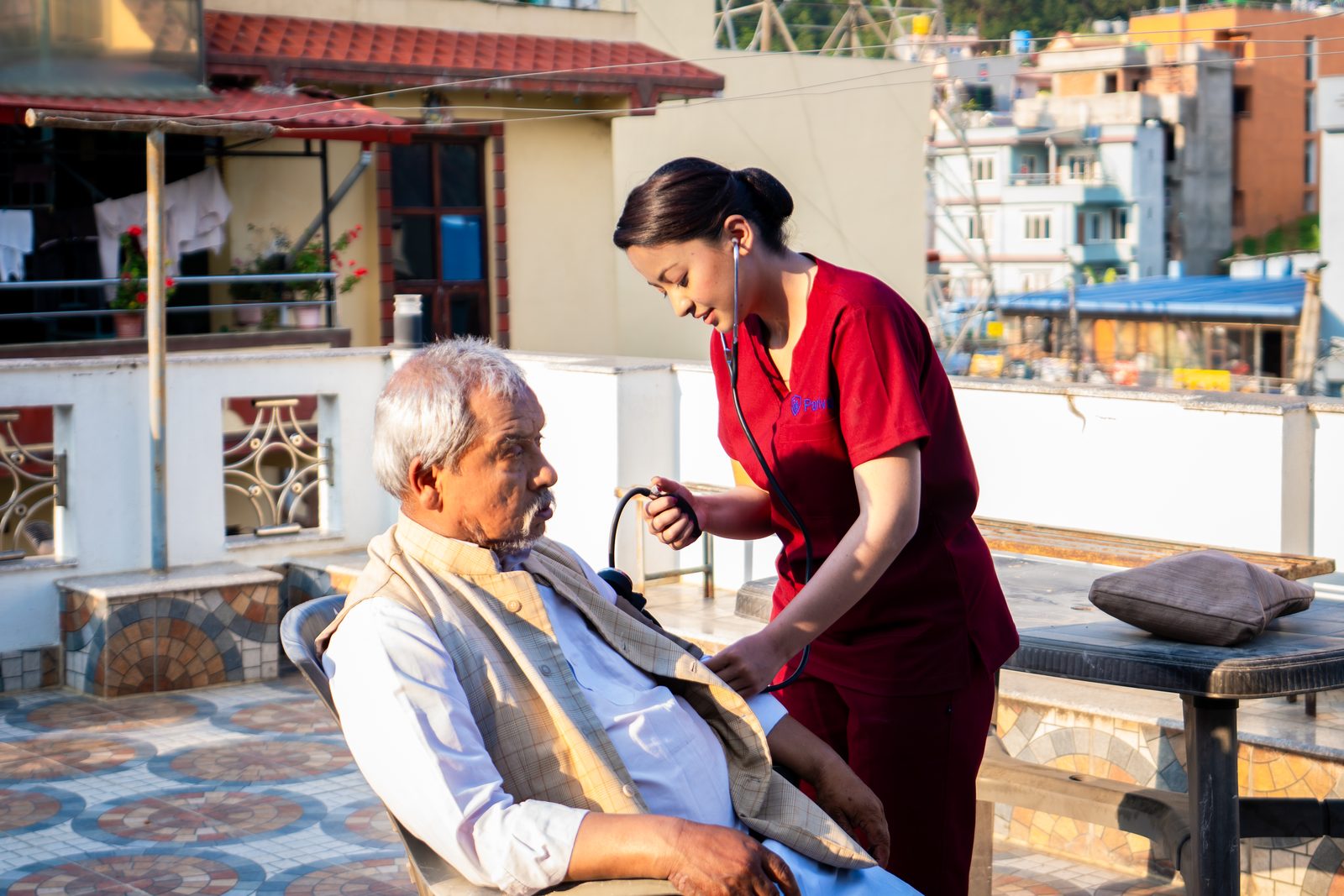 Nurse checking an elderly man's health during a home visit
